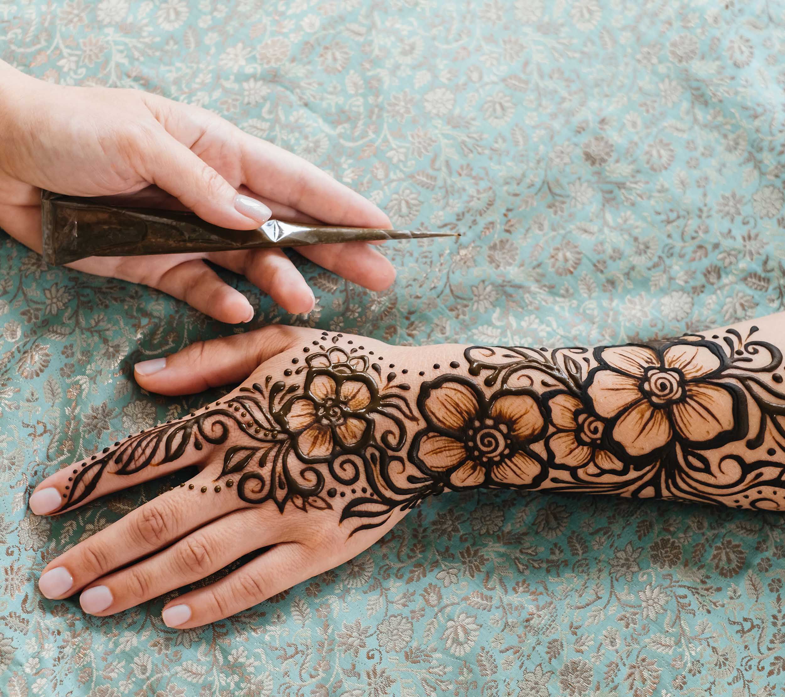Hand adorned with a modern floral mehendi design for wedding festivities